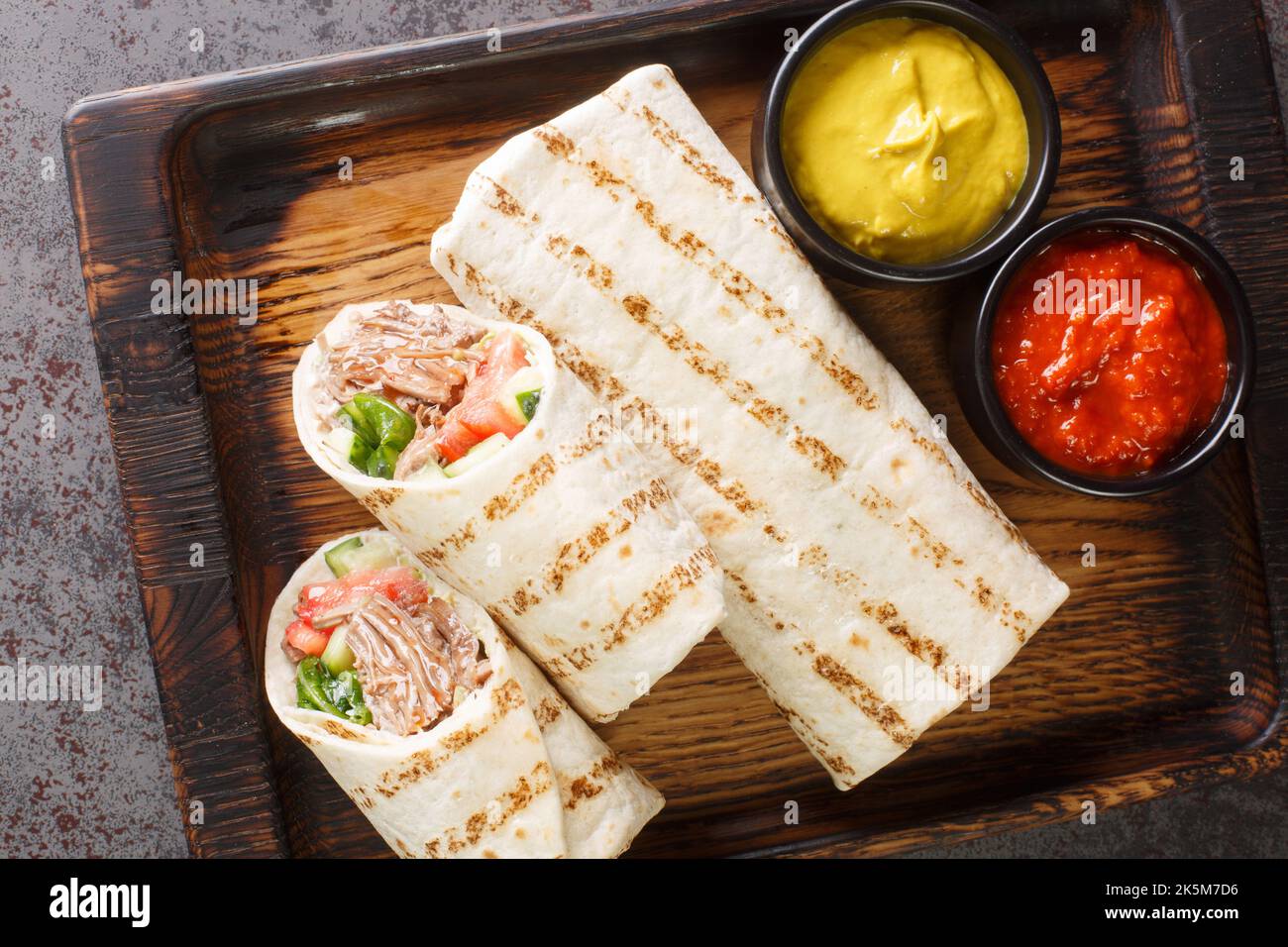 Faire un don de kebab ou de shawarma avec du bœuf et des légumes frais sur le panneau en bois de la table. Vue horizontale du dessus Banque D'Images