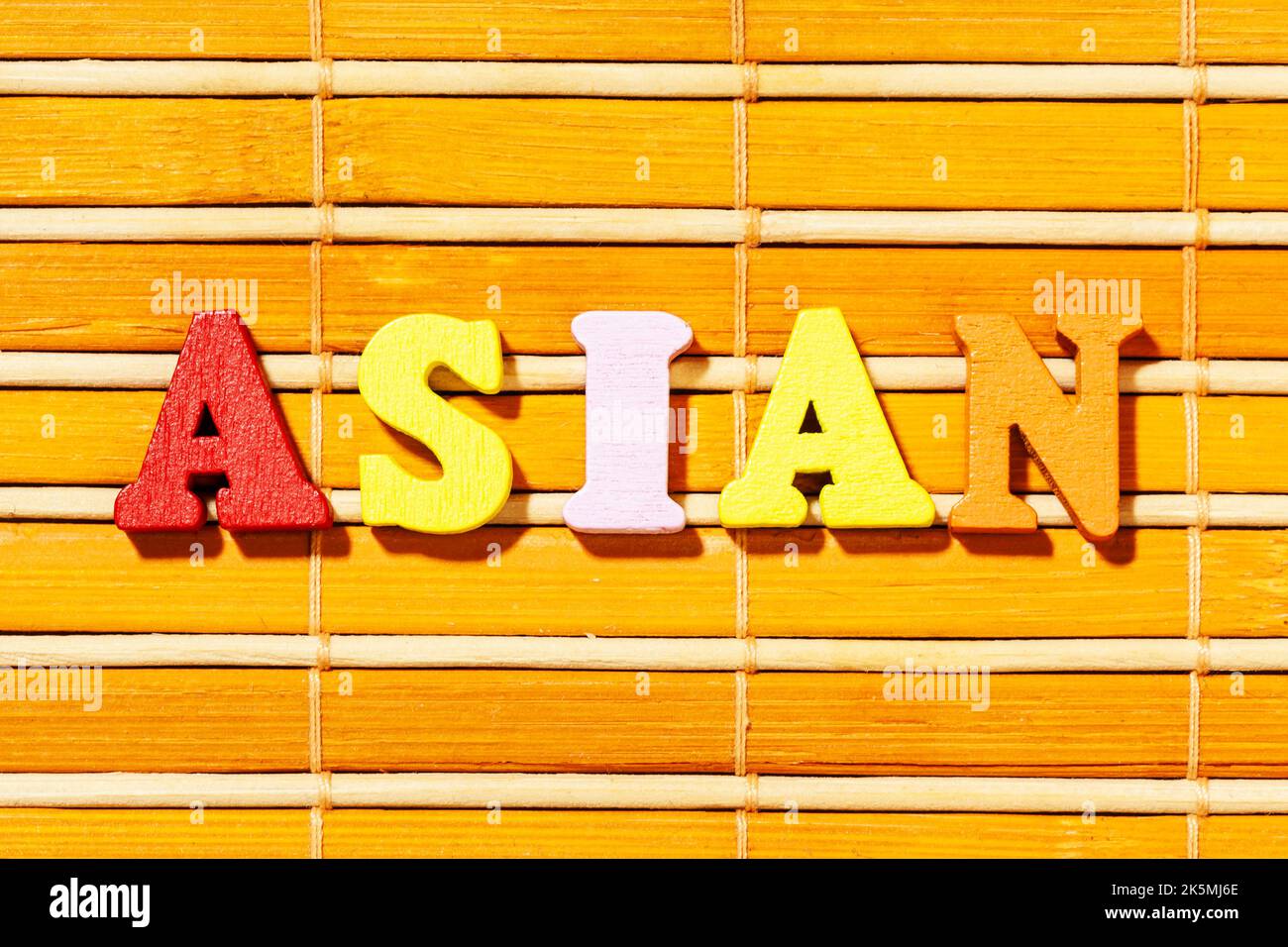 Mot asiatique - texte en lettres de couleur sur un tapis de bambou Banque D'Images