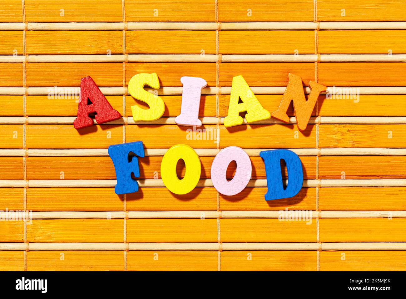 Cuisine asiatique - texte par lettres de couleur sur un tapis de bambou Banque D'Images