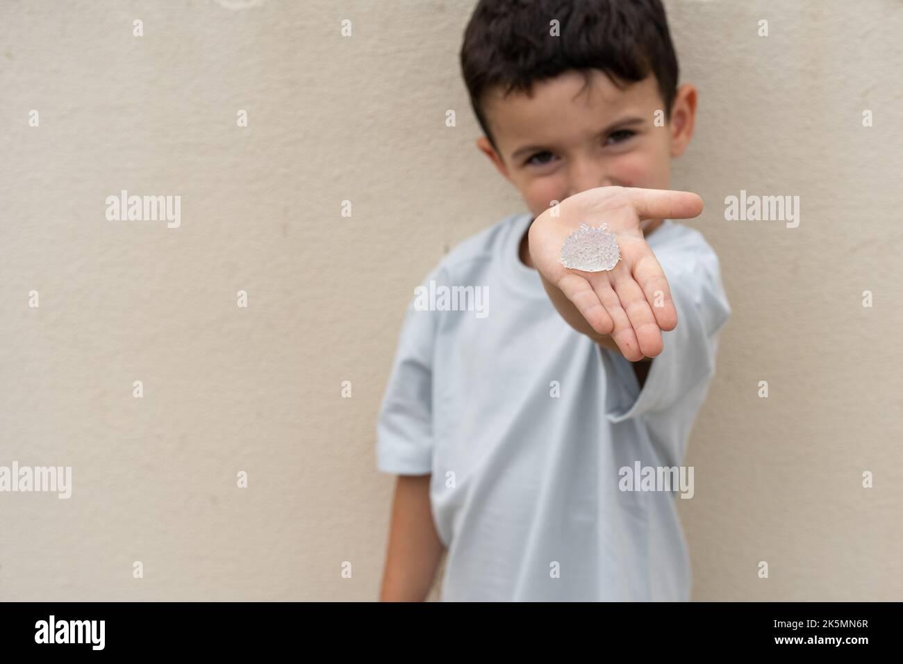 Garde d'enfants et montre des cristaux cultivés. La culture des cristaux est une expérience d'artisanat et de science amusante pour les enfants. Banque D'Images