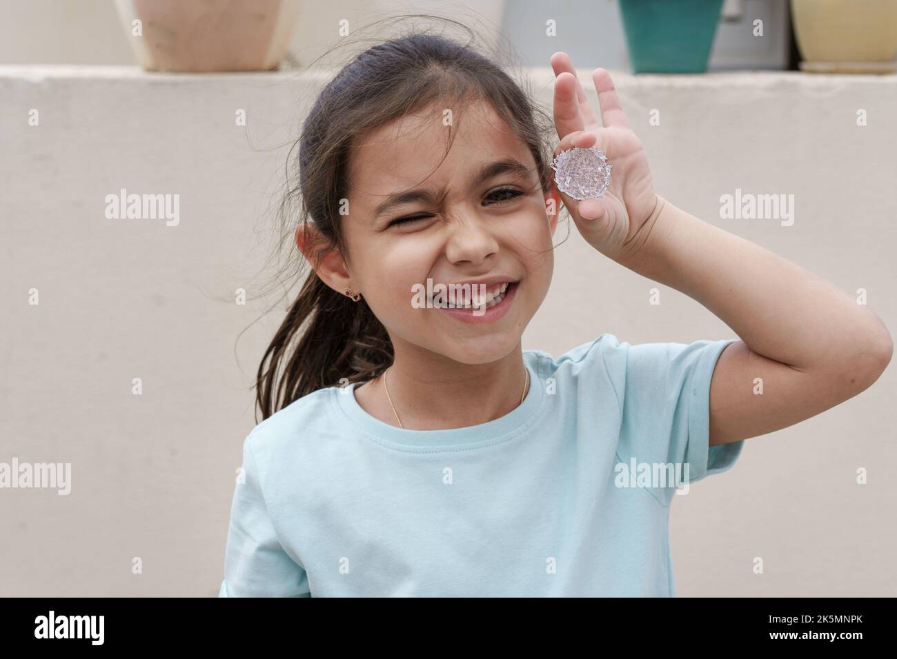 Un enfant drôle tient et montre des cristaux cultivés. La culture des cristaux est une expérience d'artisanat et de science amusante pour les enfants. Banque D'Images