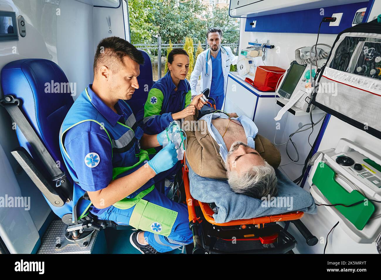 Ambulanciers Paramédicaux Effectuant Un électrocardiogramme Sur Un Patient Mature Allongé Sur Un