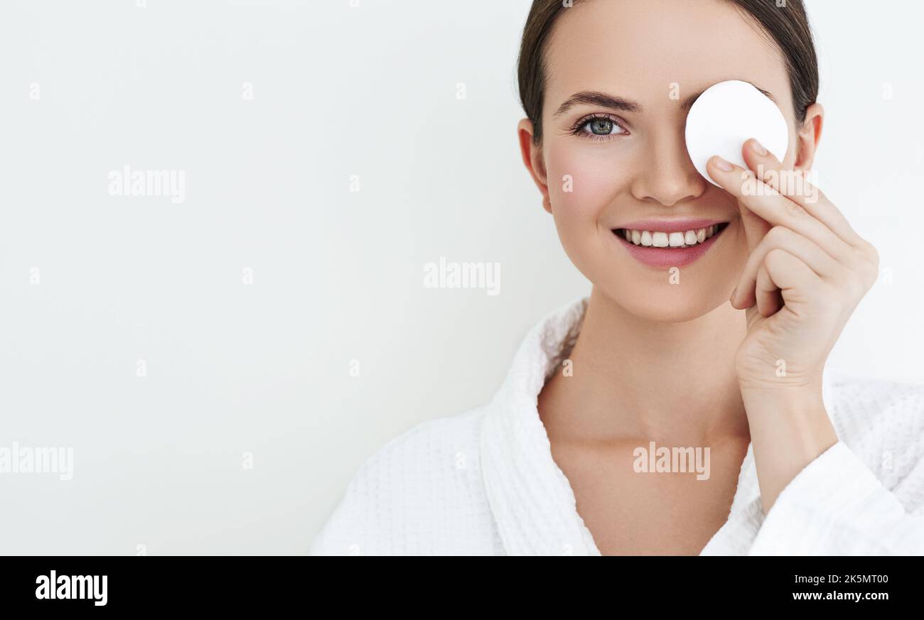 Belle femme avec tampon de coton cosmétique près de son visage prenant soin de la peau. Maquillage et élimination soins et nettoyage de la peau Banque D'Images