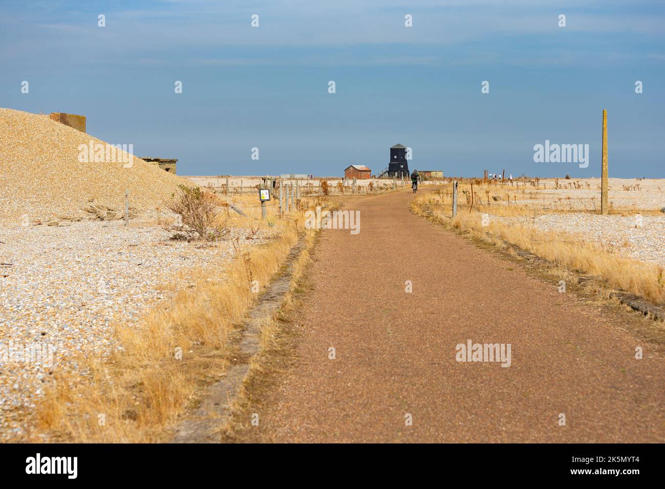 Vue le long d'une route dans l'ancien site d'essais balistiques, Orford Ness, Suffolk, Angleterre. Les bâtiments « Black Beacon » et « Power House » au loin Banque D'Images