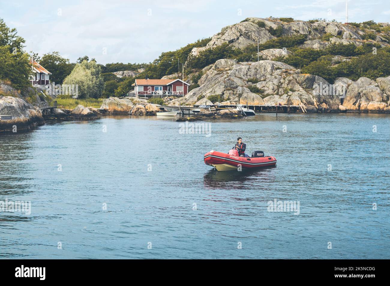 Un homme dans un petit bateau dans la mer dans l'archipel du sud de Göteborg par une journée ensoleillée Banque D'Images