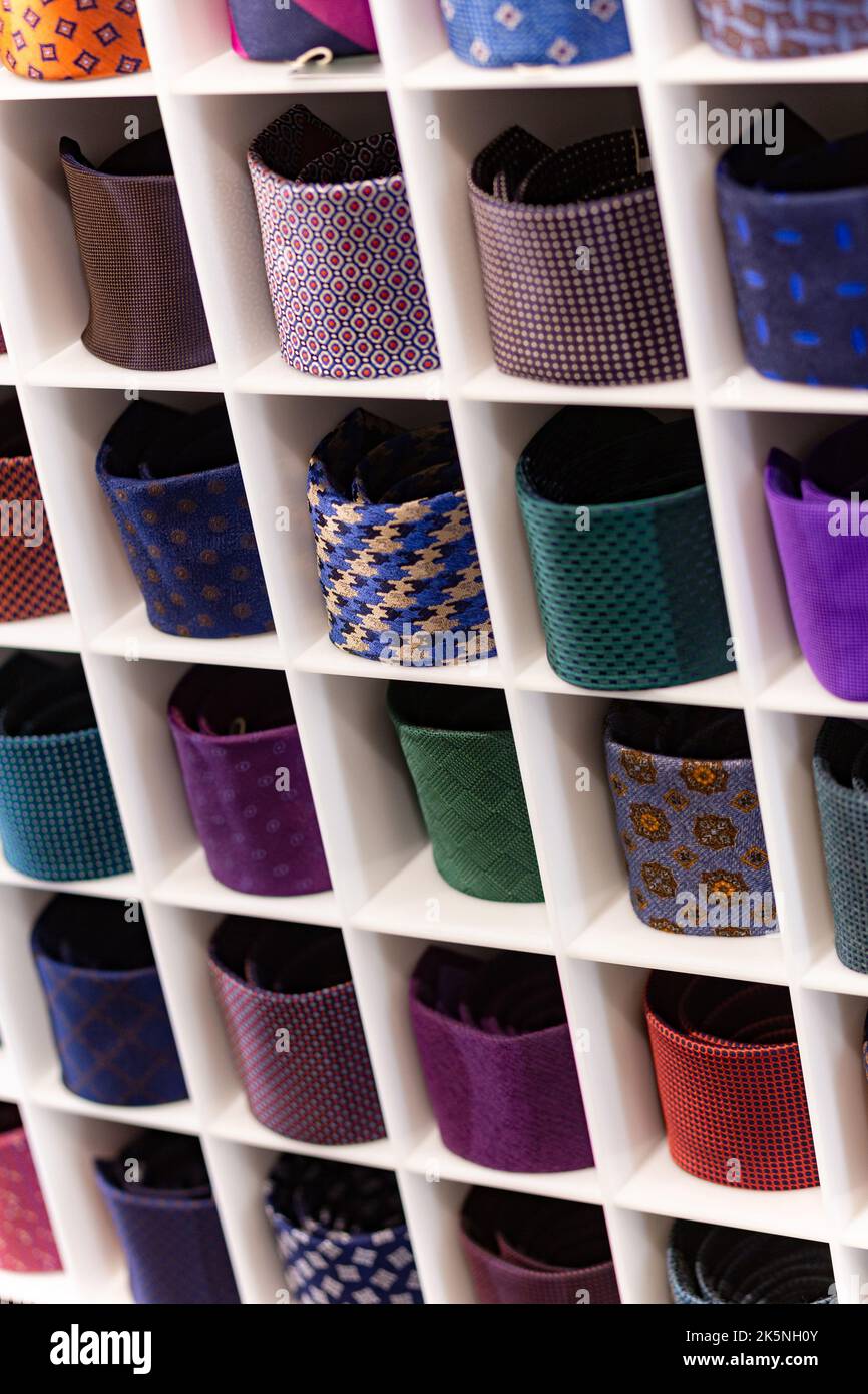 Présentation avec des cravates multicolores. Vue des différentes couleurs dans la vitrine. Présentation des cravates roulées en magasin. Les cravates torsadées sont magnifiques Banque D'Images