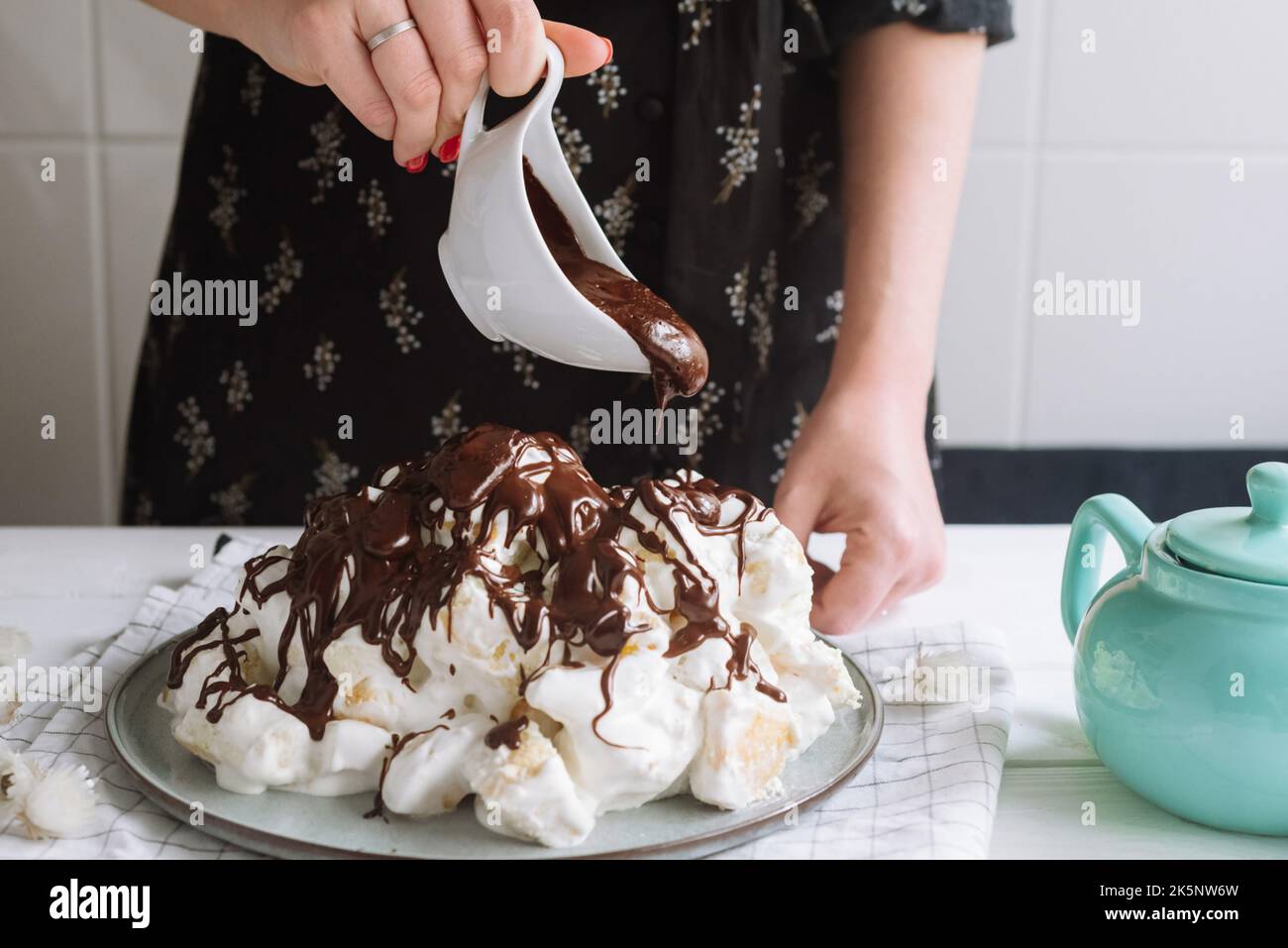 une fille verse du chocolat sur un gâteau sancho pancho maison Banque D'Images