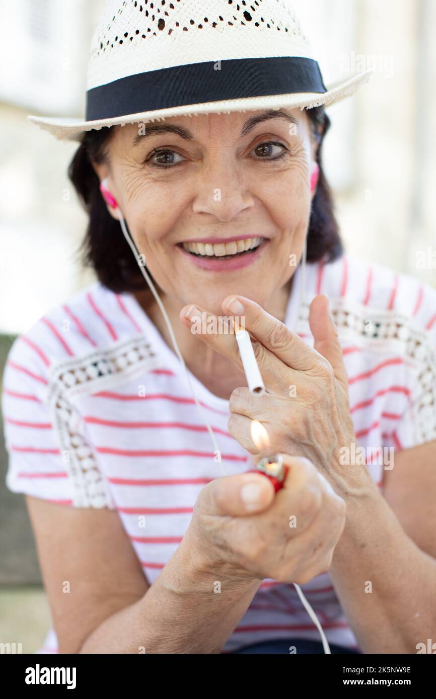 femme âgée qui apprécie une cigarette Banque D'Images