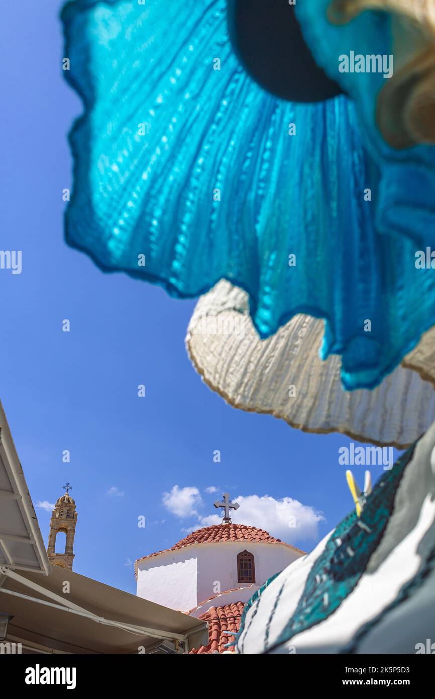 Robe nationale bleue blanche flitters dans le vent dans la vieille ville de Lindos. Rues étroites avec églises, maisons blanches sur l'île de Rhodes, Grèce. Photo de haute qualité Banque D'Images