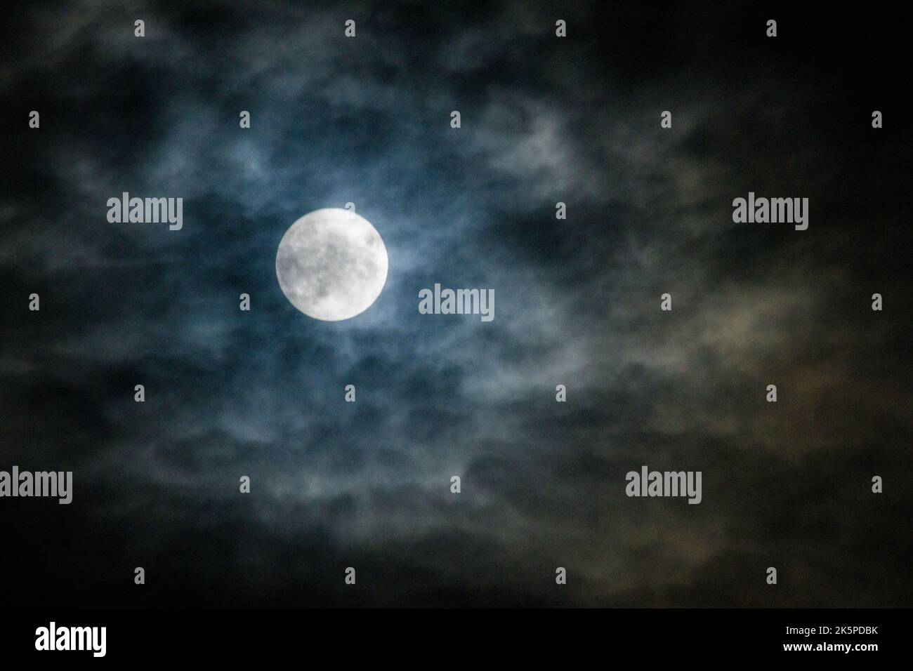 Pleine lune de Hunter voilée par des nuages, Hampshire, Angleterre, Royaume-Uni, 9 octobre 2022 Banque D'Images