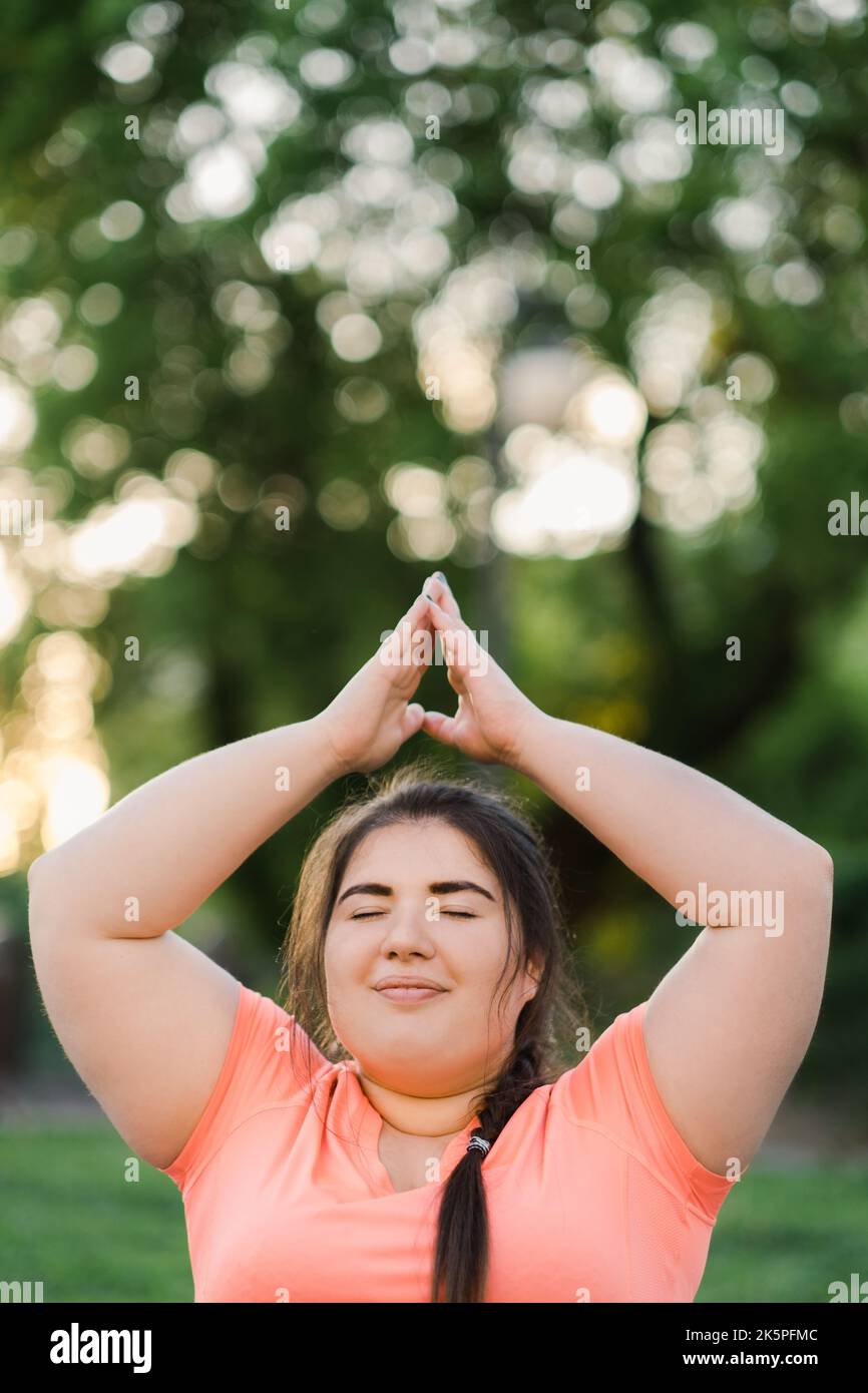 yoga bien-être parc méditation femme en surpoids Banque D'Images