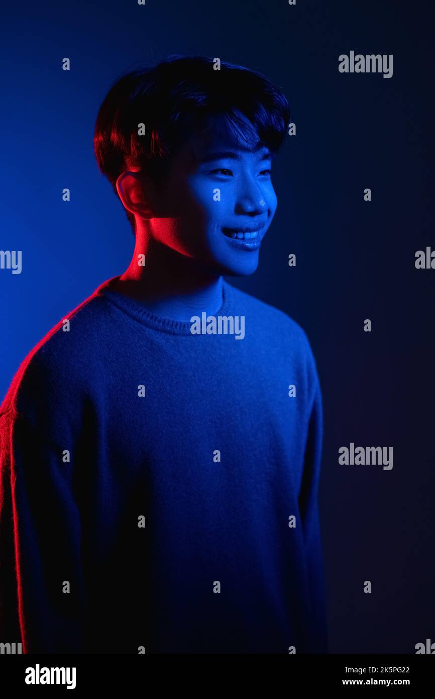 homme asiatique souriant couleur portrait lumineux bleu néon Banque D'Images homme asiatique souriant couleur portrait lumineux bleu néon Banque D'Images