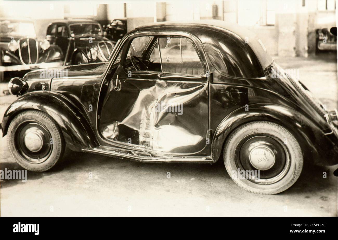 Une Fiat Topolino dans un atelier de réparation après un accident de voiture peu après la deuxième guerre mondiale (Italie) Banque D'Images