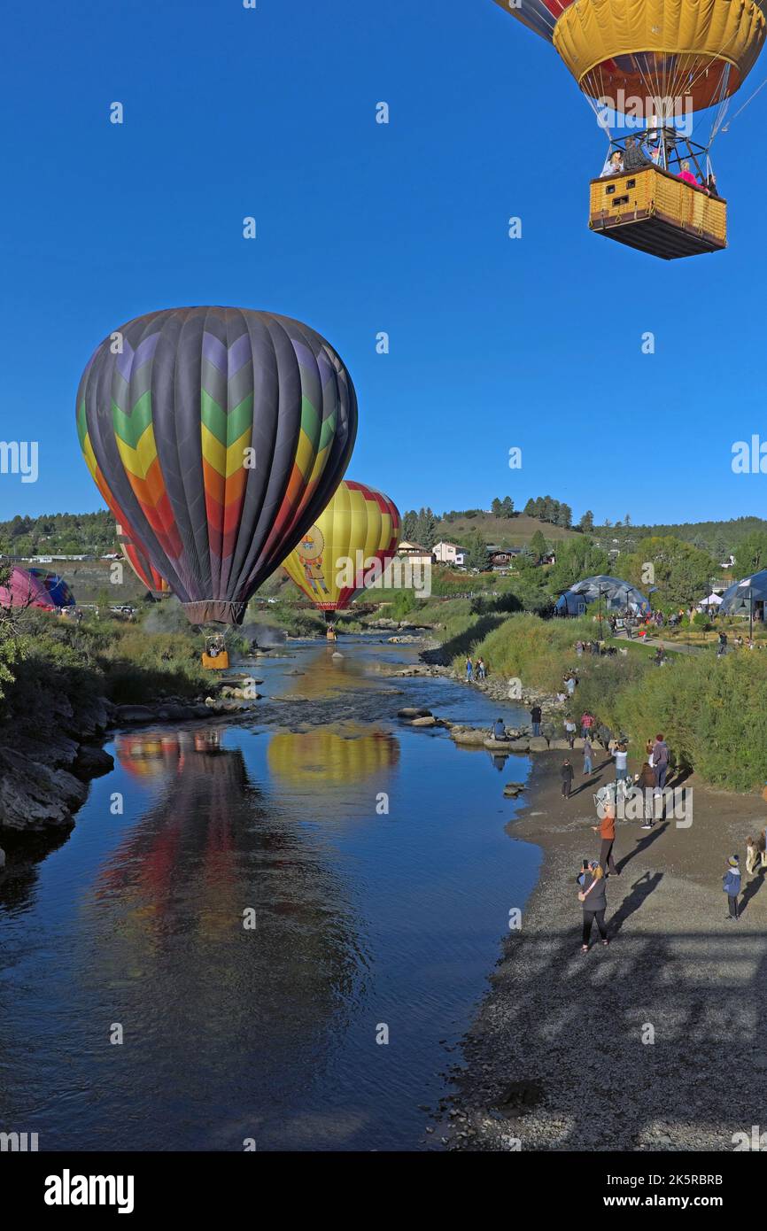 Les gens regardent depuis les rives de la rivière San Juan à Pagosa Springs, Colorado, tandis que des ballons à air chaud survolez 17 septembre 2022. Banque D'Images