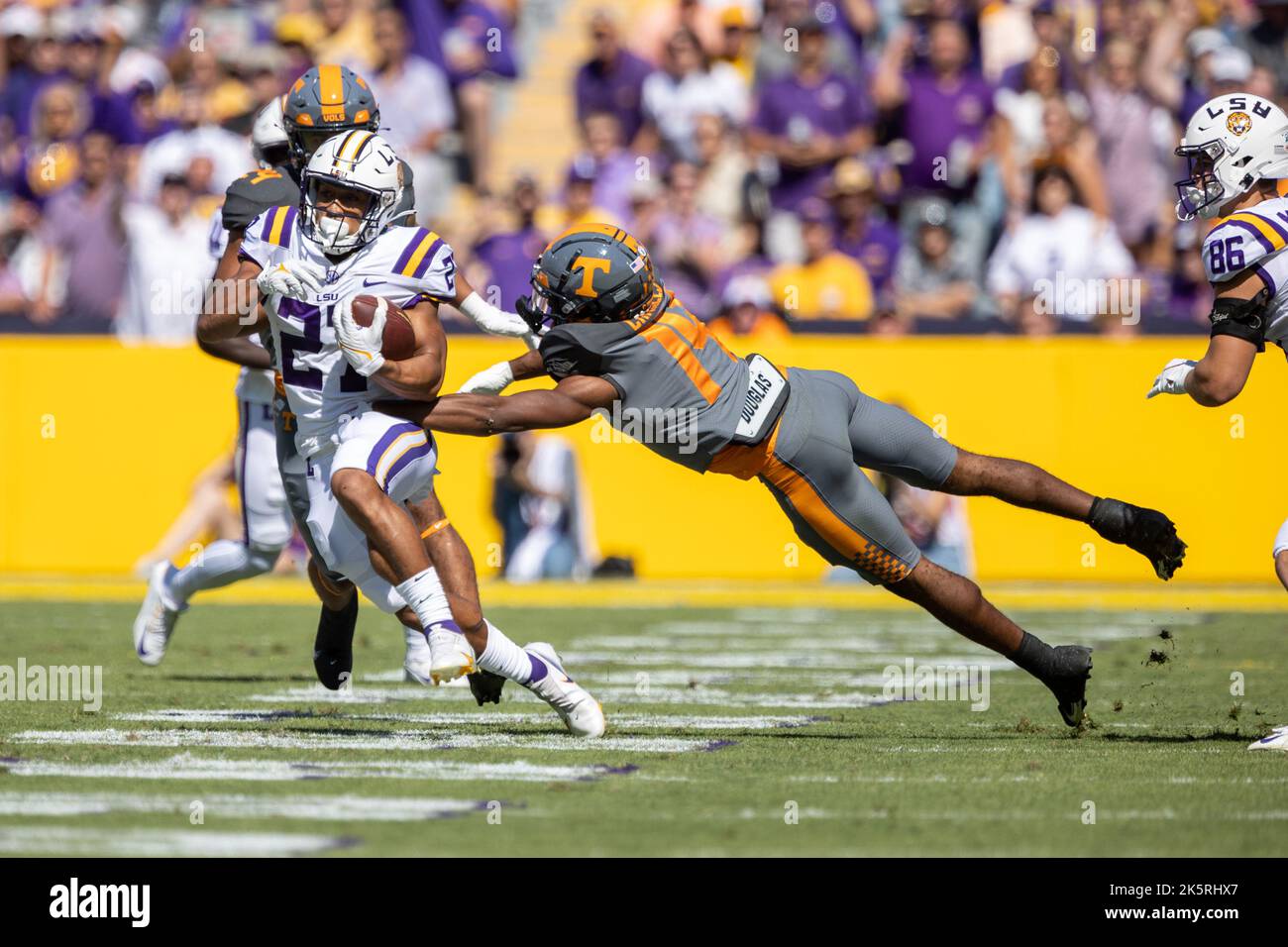 Le défenseur des volontaires du Tennessee Christian Charles (14 ans) fait une tentative de plongée alors que les LSU Tigers Running Back Josh Williams (27 ans) porte le bal Banque D'Images