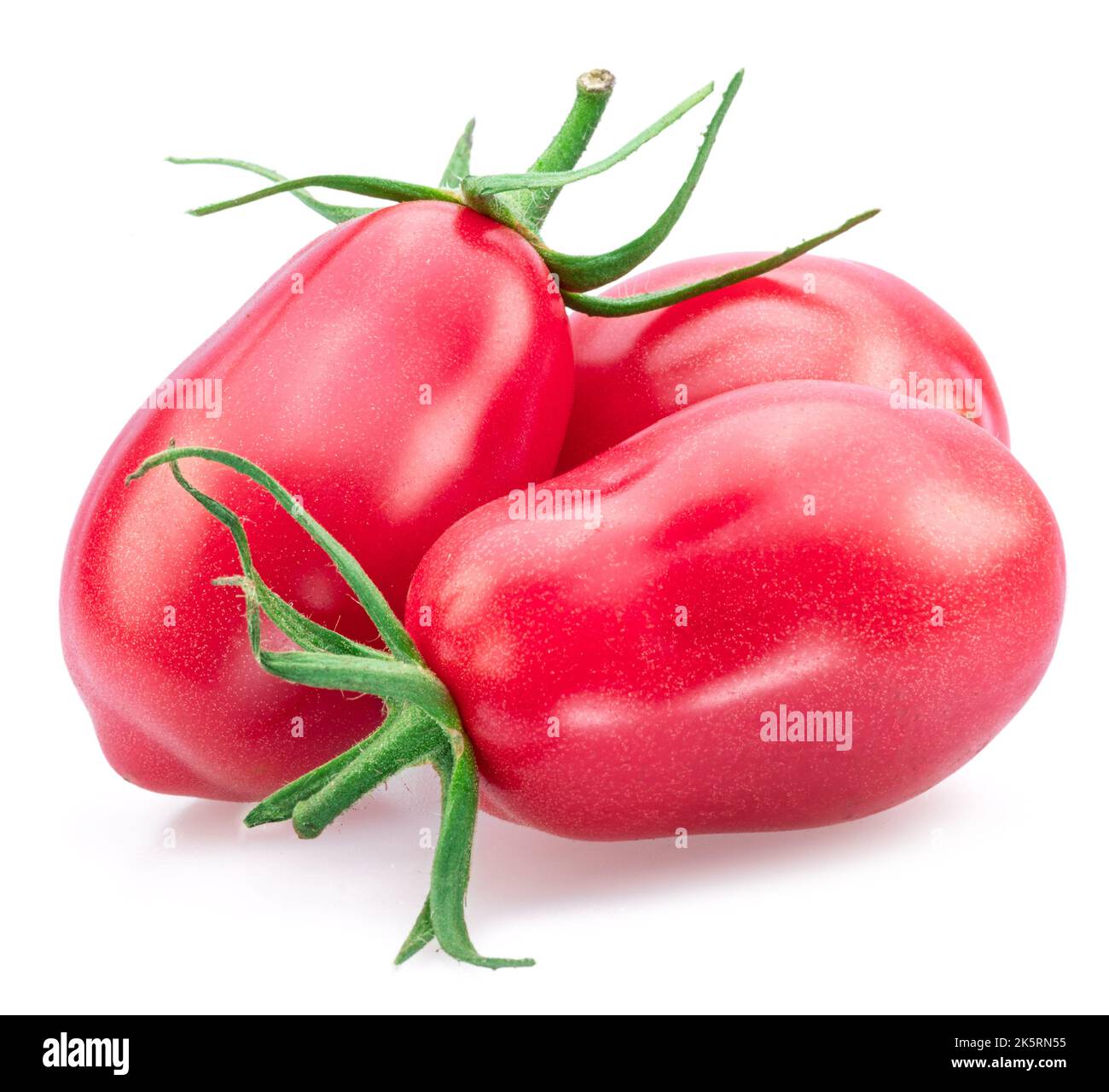 Trois tomates roses (prunes) isolées sur fond blanc. Banque D'Images
