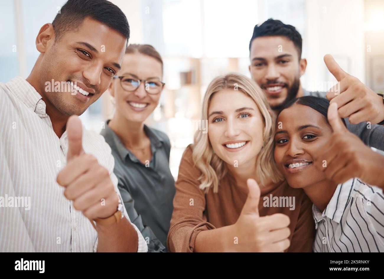 Portrait d'un groupe de personnes d'affaires confiantes et diverses qui se font des pouces et qui prennent des selfies ensemble dans un bureau. Des collègues souriants Banque D'Images