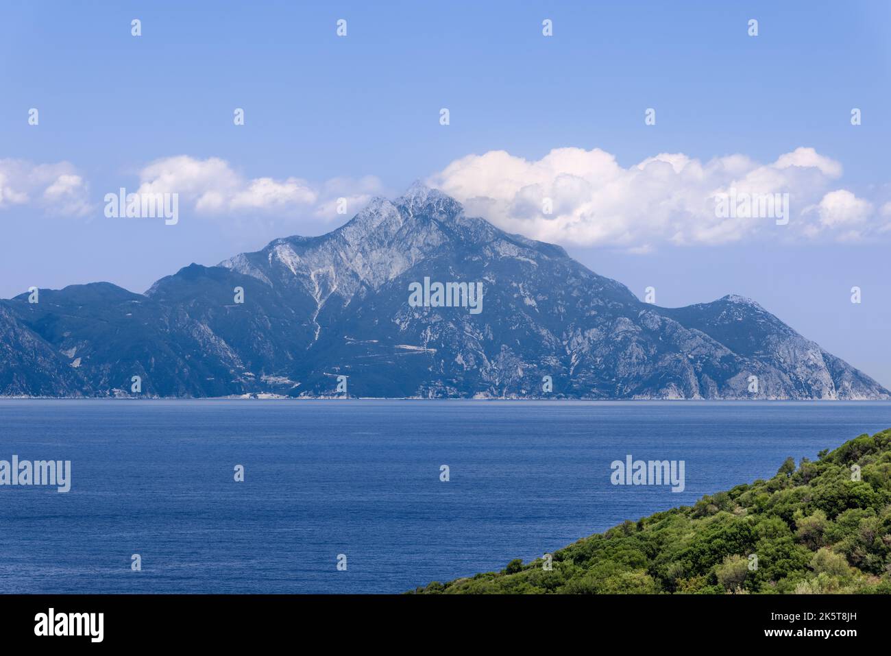 Il y a une explication simple pour la présence de nuages blancs au sommet du mont Athos tout au long de l'été: Au sommet de la montagne, l'air est froid, le fond est chaud, l'eau et humi Banque D'Images