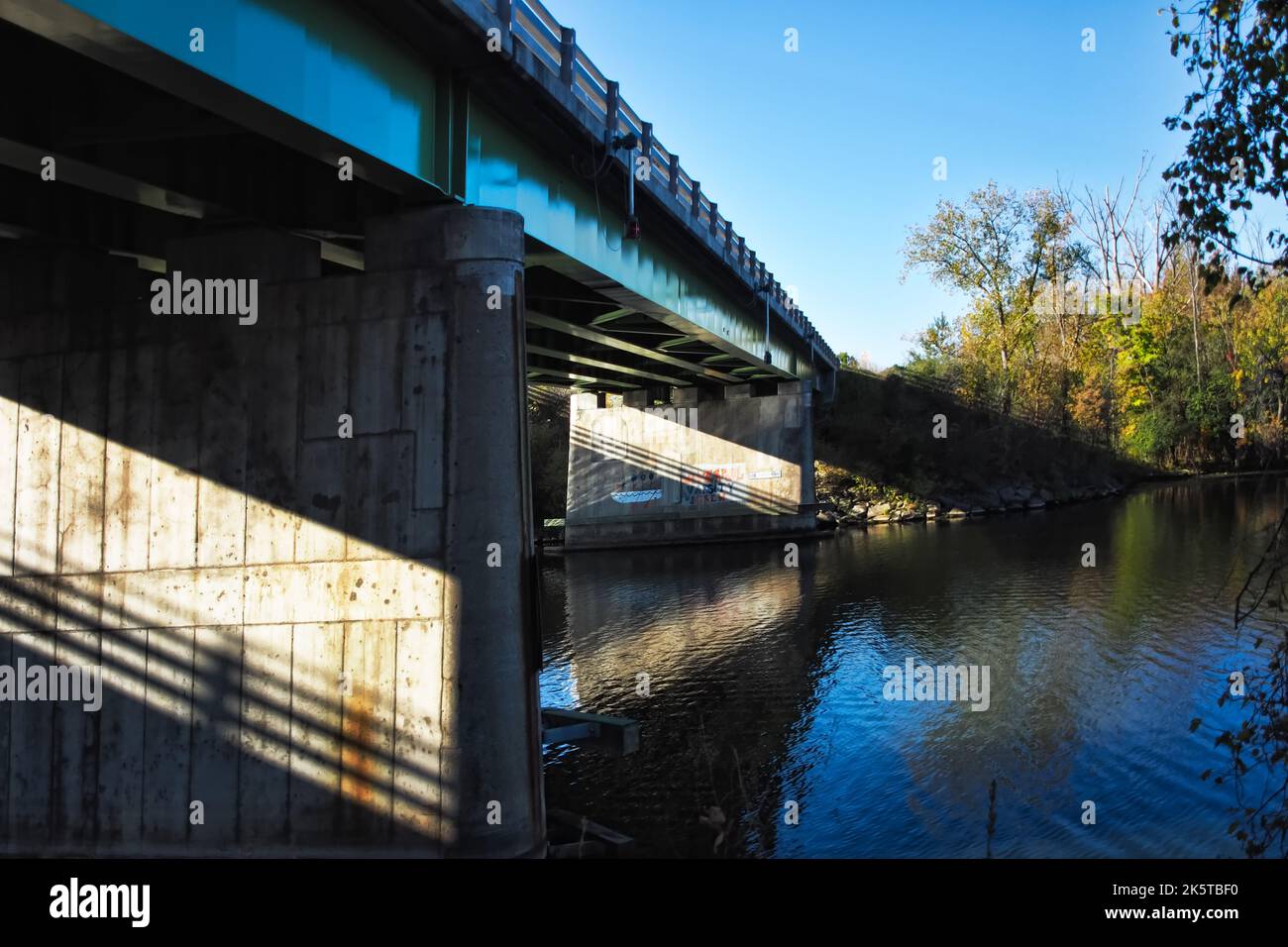 Lumière du soleil sur le renforcement d'un pont en béton sous un pont à chemin de chemin de chemin de chemin dans Onondaga Lake Park à Liverpool, New York en automne Banque D'Images