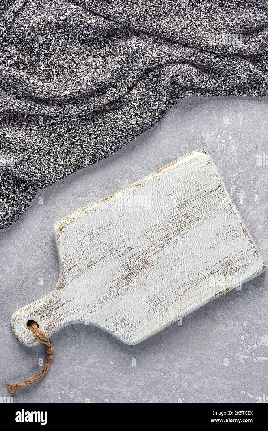 Salle de découpe en bois blanc et serviette de cuisine grise sur une table en béton gris clair Banque D'Images