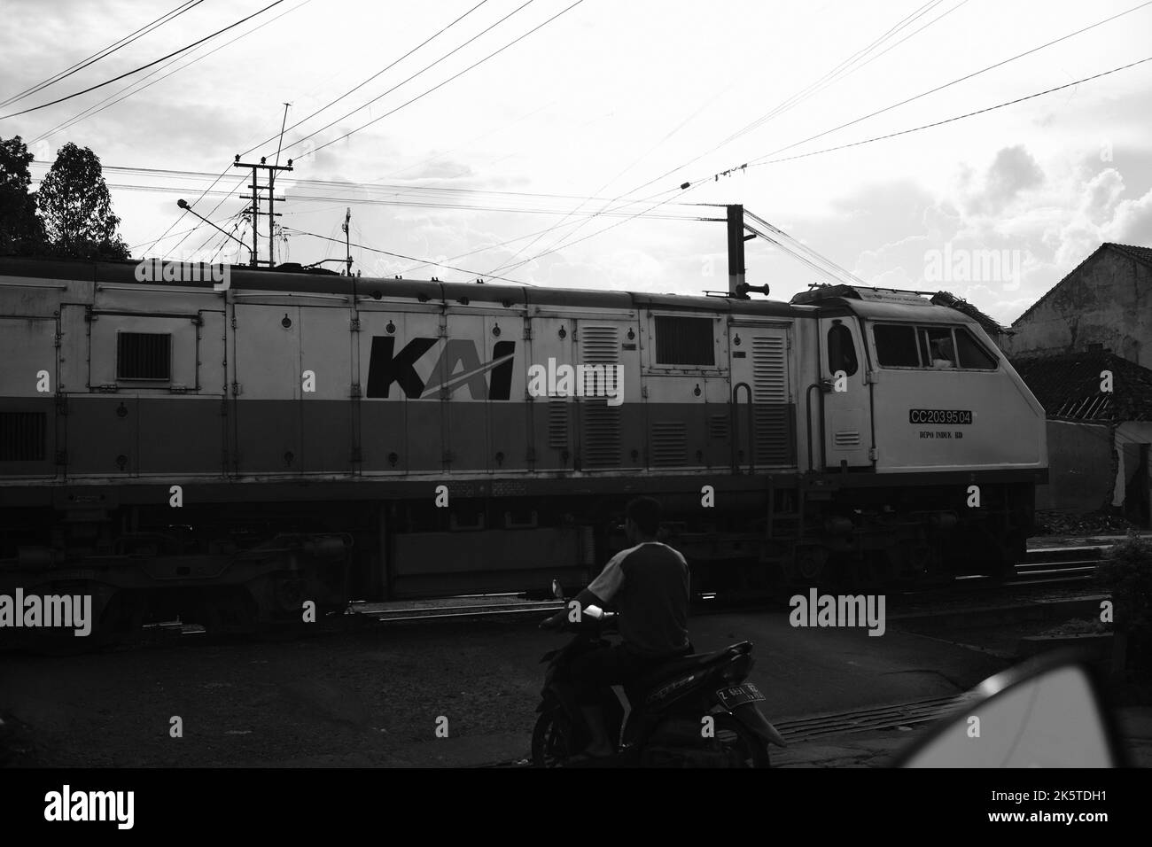 Cicalengka, West Java, Indonésie - 09 octobre 2022 : passage du train, photo monochrome au passage à niveau, où plusieurs personnes attendent le train Banque D'Images