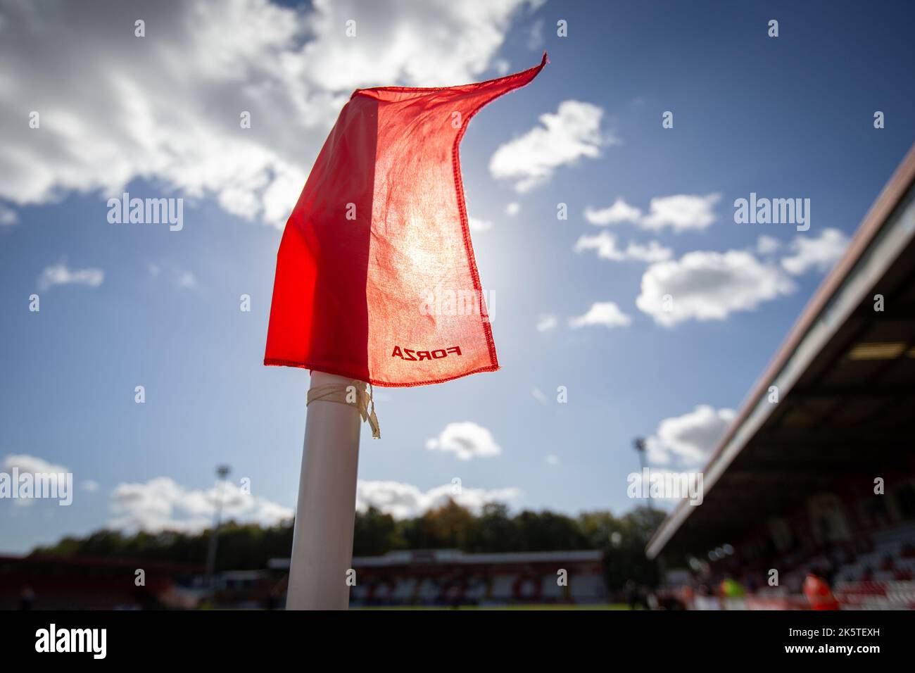 Gros plan sur le drapeau d'angle qui flotte dans le vent au stade de football, rétroéclairé par la lumière du soleil Banque D'Images