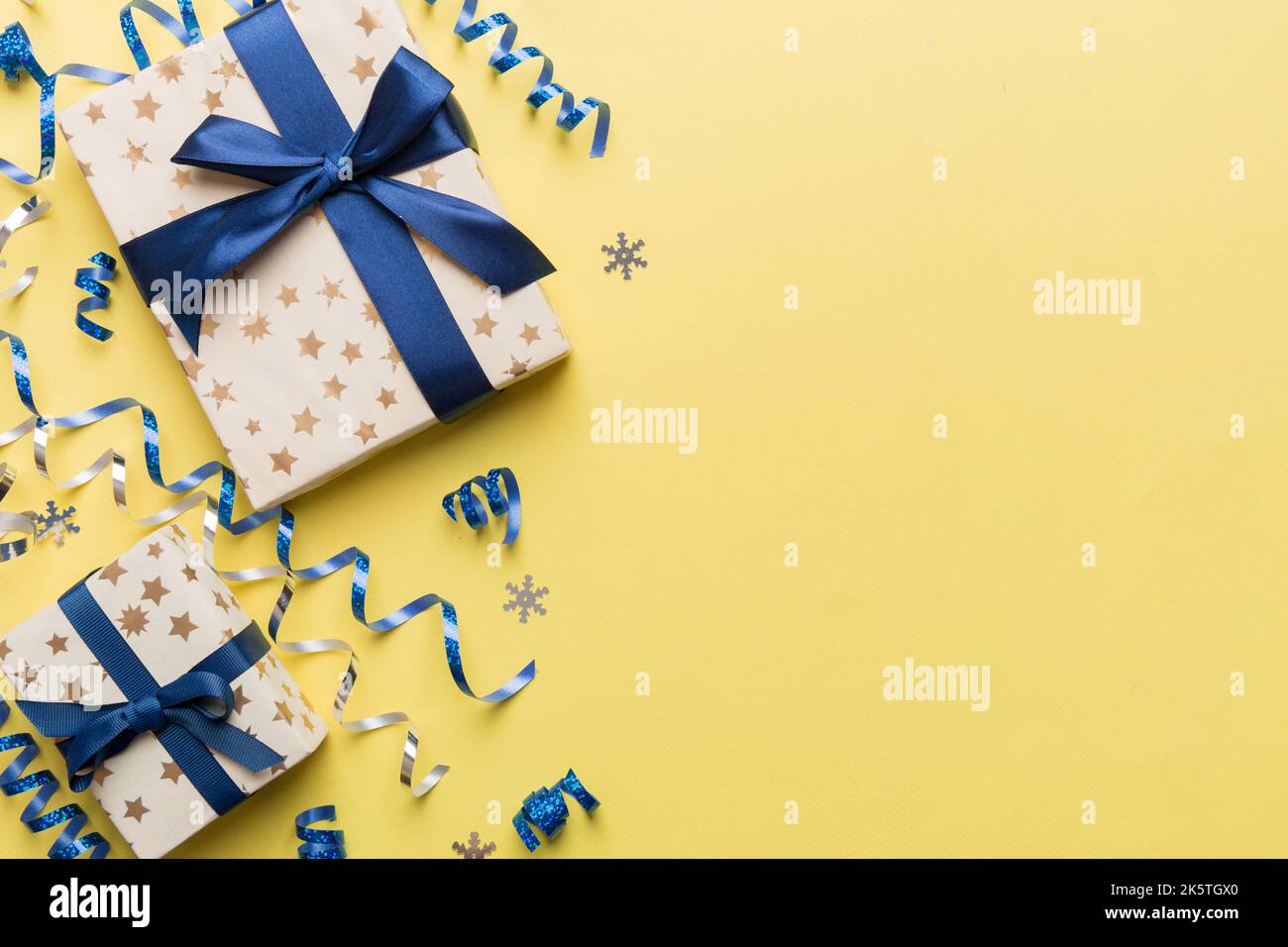 Appartement de vacances avec boîtes cadeaux enveloppées dans du papier coloré et noué décoré de confetti sur fond coloré. Noël, anniversaire, Saint-Valentin et Banque D'Images