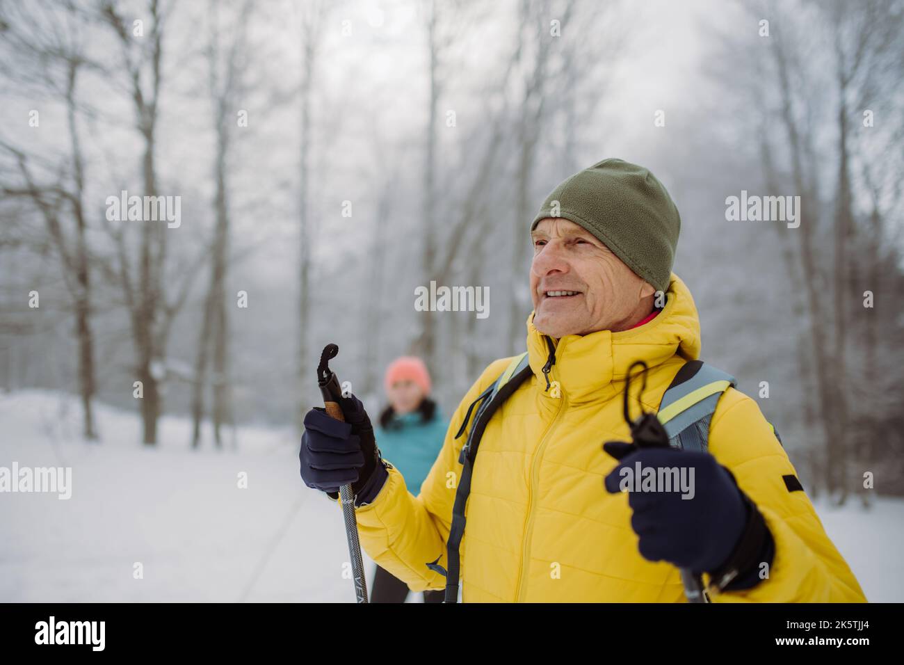 Homme senior admirant la nature pendant le ski de fond avec sa femme. Banque D'Images