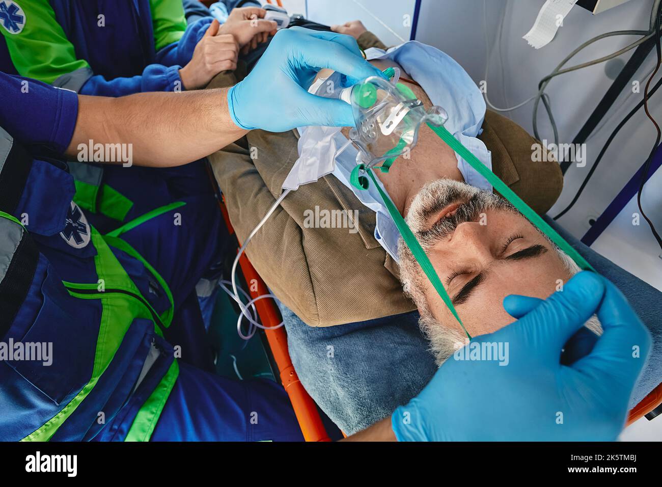 Ambulanceman mettant le masque d'oxygène sur le patient en ambulance pendant le voyage à l'hôpital. Transport en ambulance et premiers soins Banque D'Images