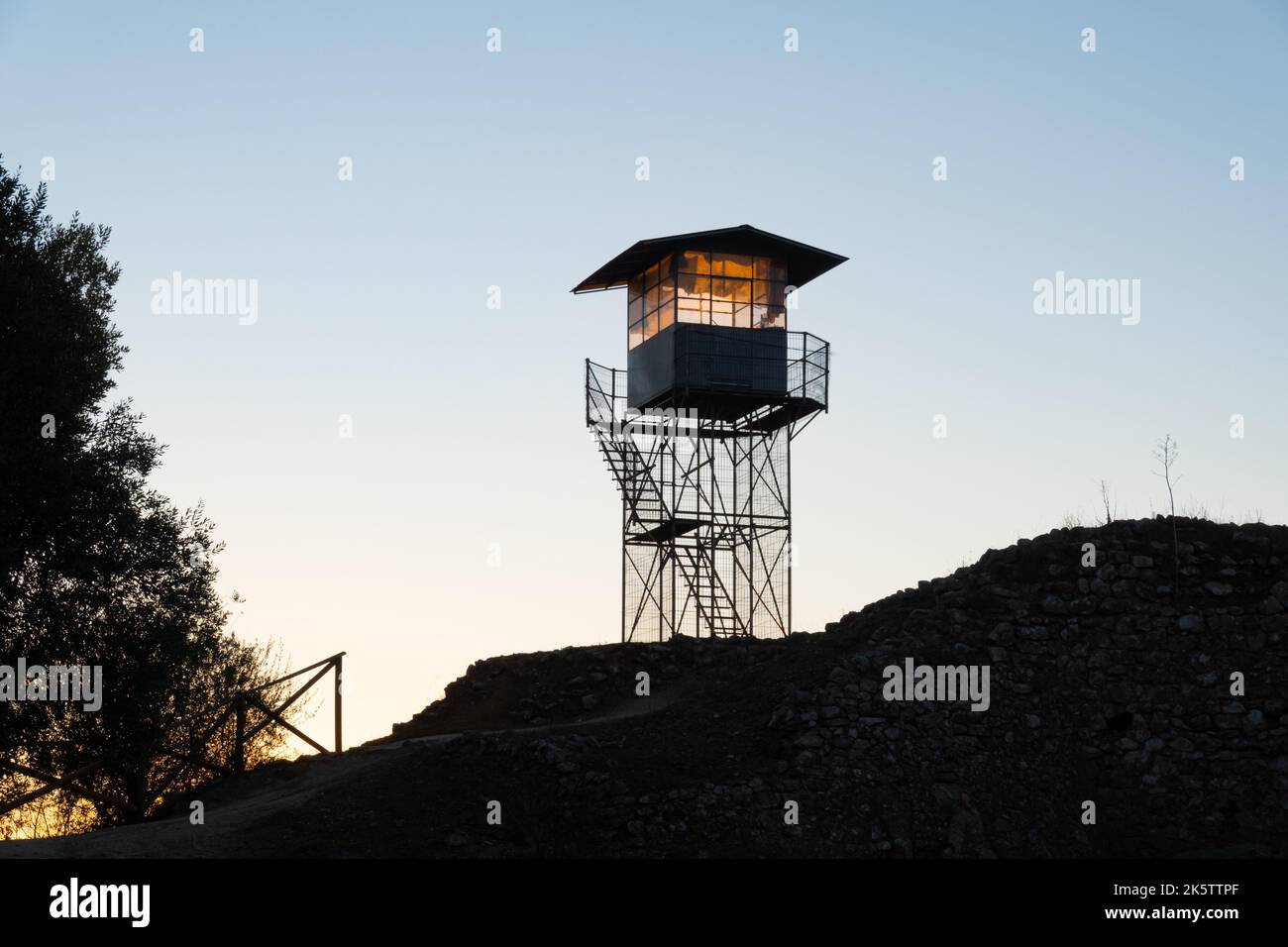 Tour de guet pour la surveillance des incendies en silhouette au sommet d'une colline surplombant la campagne au lever du soleil dans l'Alentejo Portugal Banque D'Images