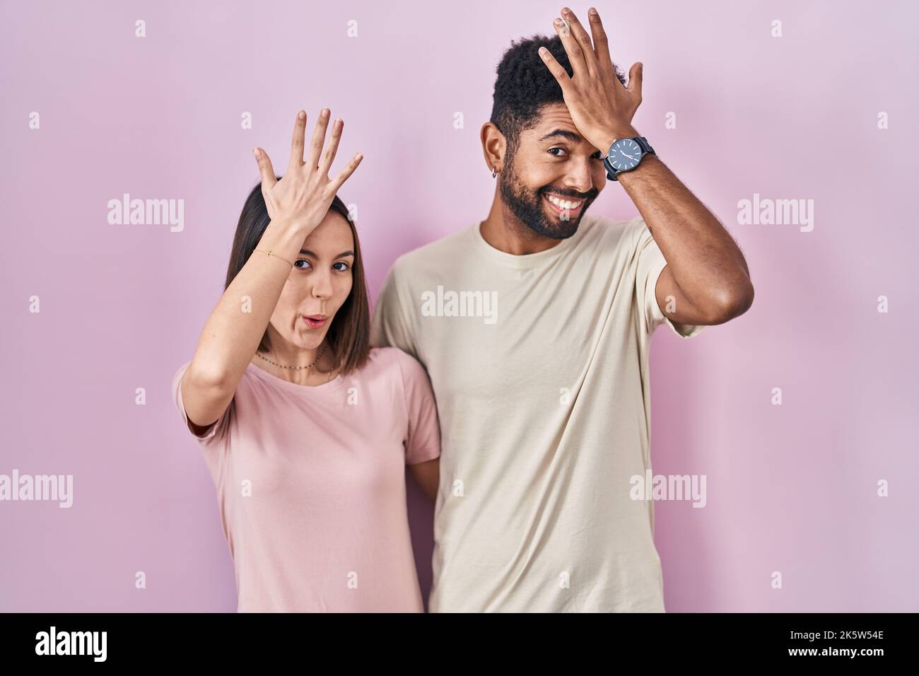 Jeune couple hispanique ensemble sur fond rose surpris par la main sur la tête pour l'erreur, souvenez-vous de l'erreur. oublié, mauvais concept de mémoire. Banque D'Images Jeune couple hispanique ensemble sur fond rose surpris par la main sur la tête pour l'erreur, souvenez-vous de l'erreur. oublié, mauvais concept de mémoire. Banque D'Images