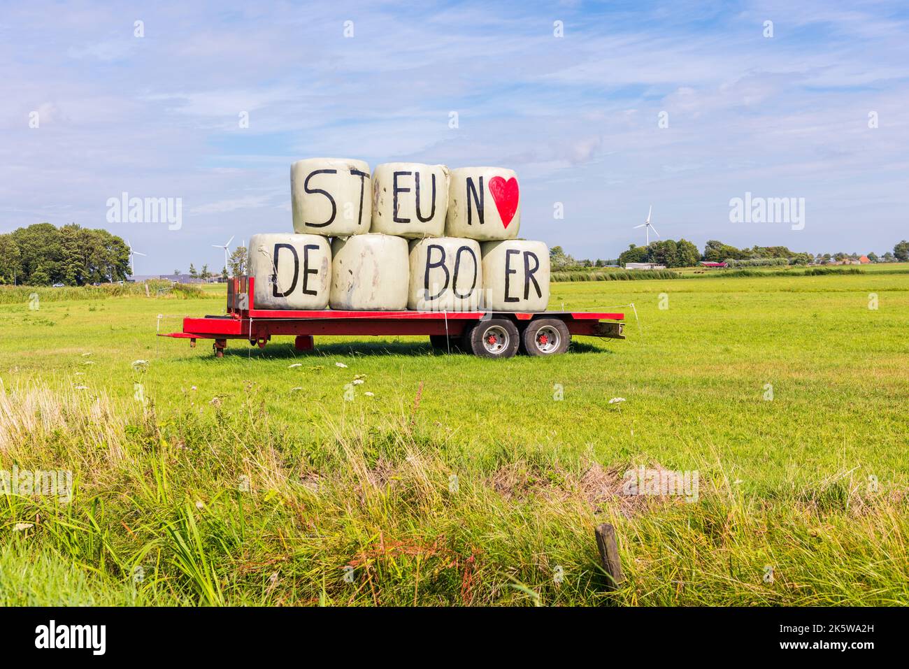 Soutenir les lettres Farmer sur les balles de foin sur la remorque dans la prairie à Heiloo, aux pays-Bas. Banque D'Images