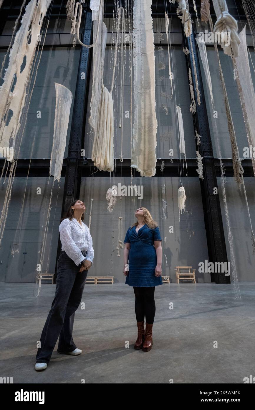 Londres, Royaume-Uni. 10 octobre 2022. Membres du personnel lors du dévoilement de la Commission Hyundai de cette année dans le hall turbine de Tate Modern par Cecilia Vicuña. L’installation nommée ‘Brain Forest Quipu’ comprend deux sculptures de quipu de 27 mètres de hauteur et poursuit le travail de longue date de l’artiste avec l’ancienne tradition andine du quipu et est en exposition du 11 octobre 2022 au 16 avril 2023. Credit: Stephen Chung / Alamy Live News Banque D'Images