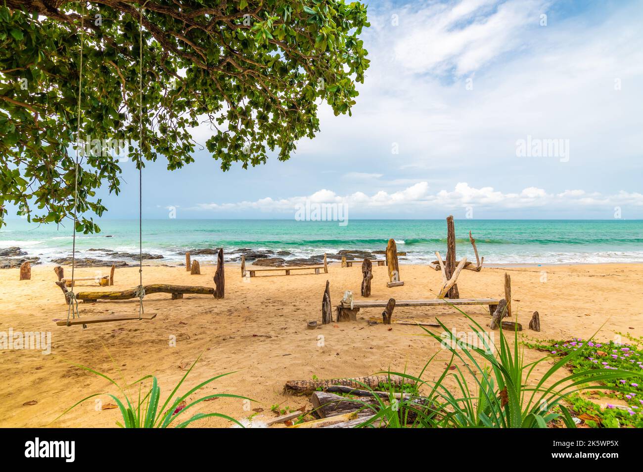 Plage de Khlong hin sur l'île de Ko Lanta, Thaïlande. Vue sur la plage avec arbres et balançoire. Lieu de détente près de la mer turquoise. Plantes tropicales dans le foregro Banque D'Images