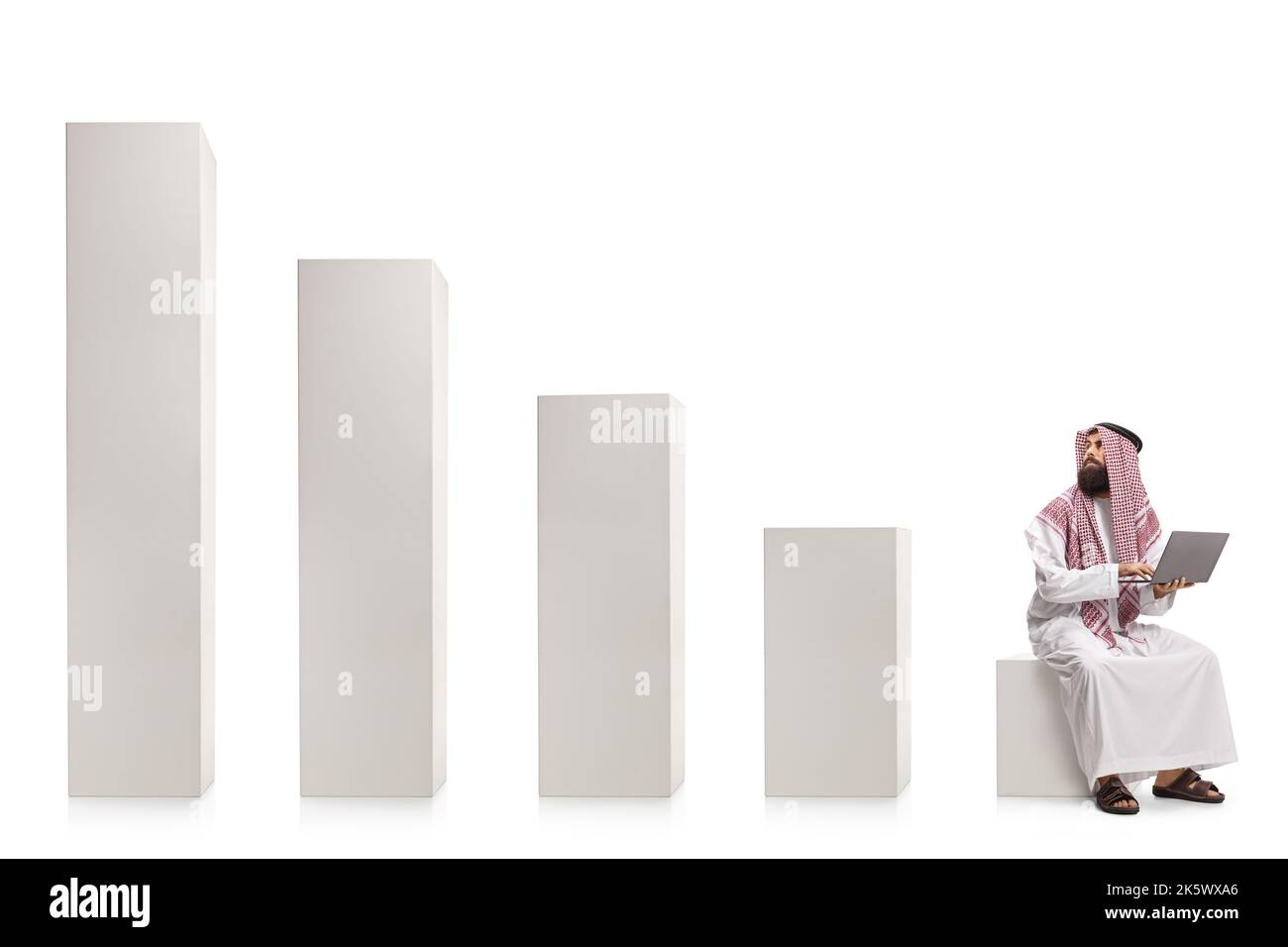 Homme arabe saoudien avec un ordinateur portable assis sur un graphique à colonnes regardant les barres montantes isolées sur fond blanc Banque D'Images