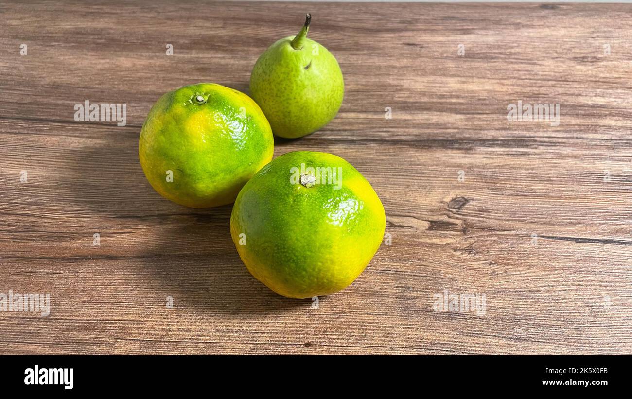 Deux oranges et une poire sur une table en bois. Banque D'Images
