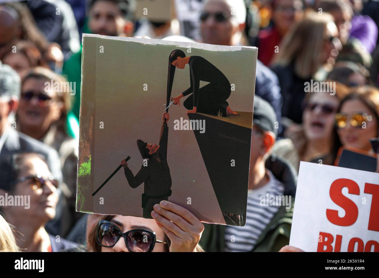 Un manifestant détient un écriteau qui dépeint la police morale de l'Iran et une jeune fille iranienne à poil long, symbolisant la mort au régime lors de la manifestation sur le Mallieveld, la Haye. Les Iraniens et leurs partisans ont rassemblé des centaines de personnes fortes à la Haye, pour soutenir les Iraniens qui protestaient dans les rues iraniennes. Les forces de sécurité en Iran ont sévi contre les manifestants après l'arrestation et la mort soudaine de Mahsa Amin, 22 ans, et de Nika Shakarami, 17 ans. Ces arrestations ont eu lieu alors qu'elles assistaient à une démonstration de protestation pour Mahsa Amin. Amin, a été arrêté par la police de moralité pour le port inapproprié de son foulard de hijab Banque D'Images
