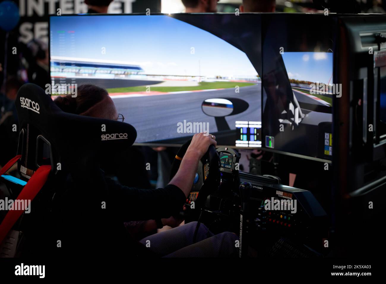 Pologne, Poznan - 09 octobre 2022: Les gens jouent un simulateur de course à la PGA. Événement lié aux jeux informatiques et aux divertissements. Banque D'Images