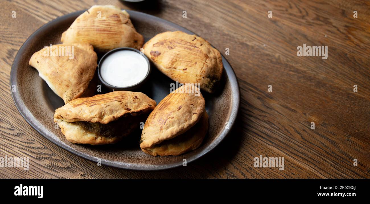 Une assiette de pierogi cuit au four sur une table de restaurant. Banque D'Images