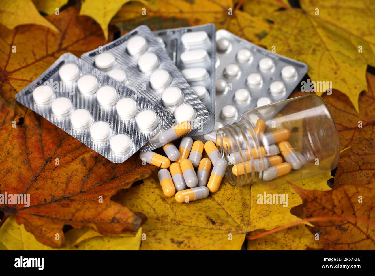 Pilules sur les feuilles d'érable orange, bouteille de capsules et paquets de comprimés. Pharmacie, antidépresseurs, vitamines pour l'immunité en automne saison de la grippe Banque D'Images