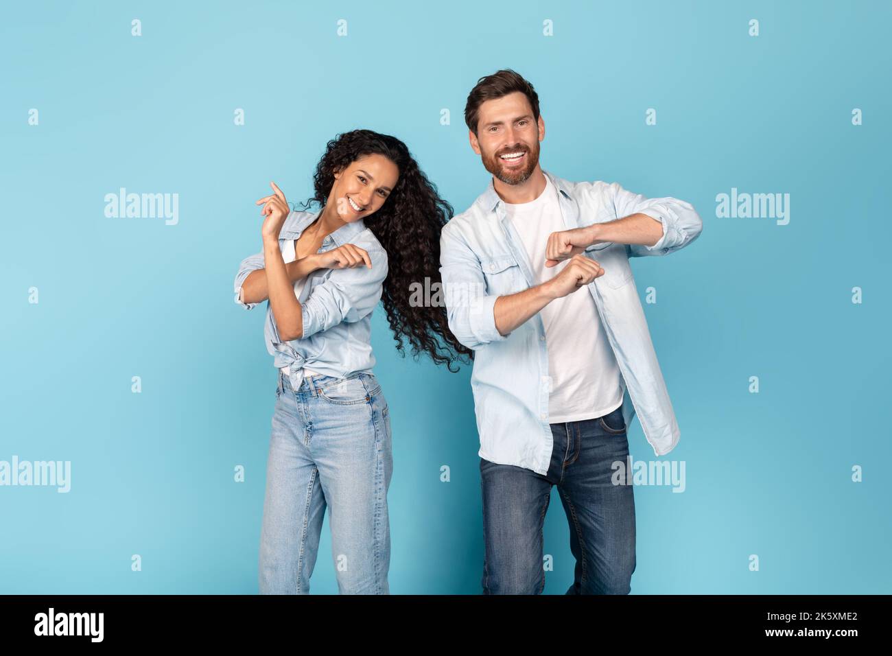 Joyeux homme du millénaire caucasien avec la barbe et la femme arabe en danse décontractée, amusez-vous ensemble Banque D'Images