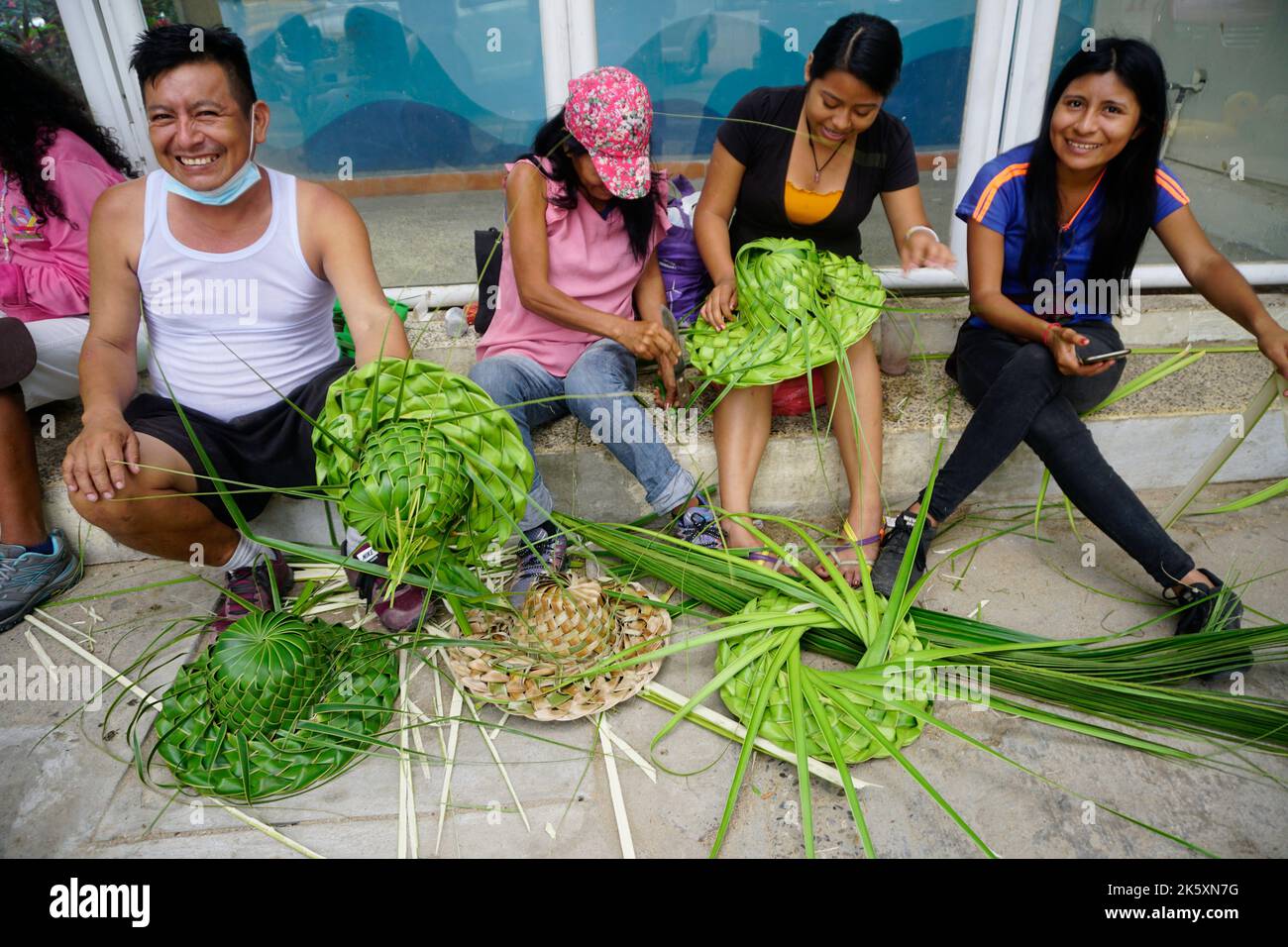 Membres de la famille qui font des chapeaux de feuilles de palmier à noix de coco, Acapulco, Mexique Banque D'Images