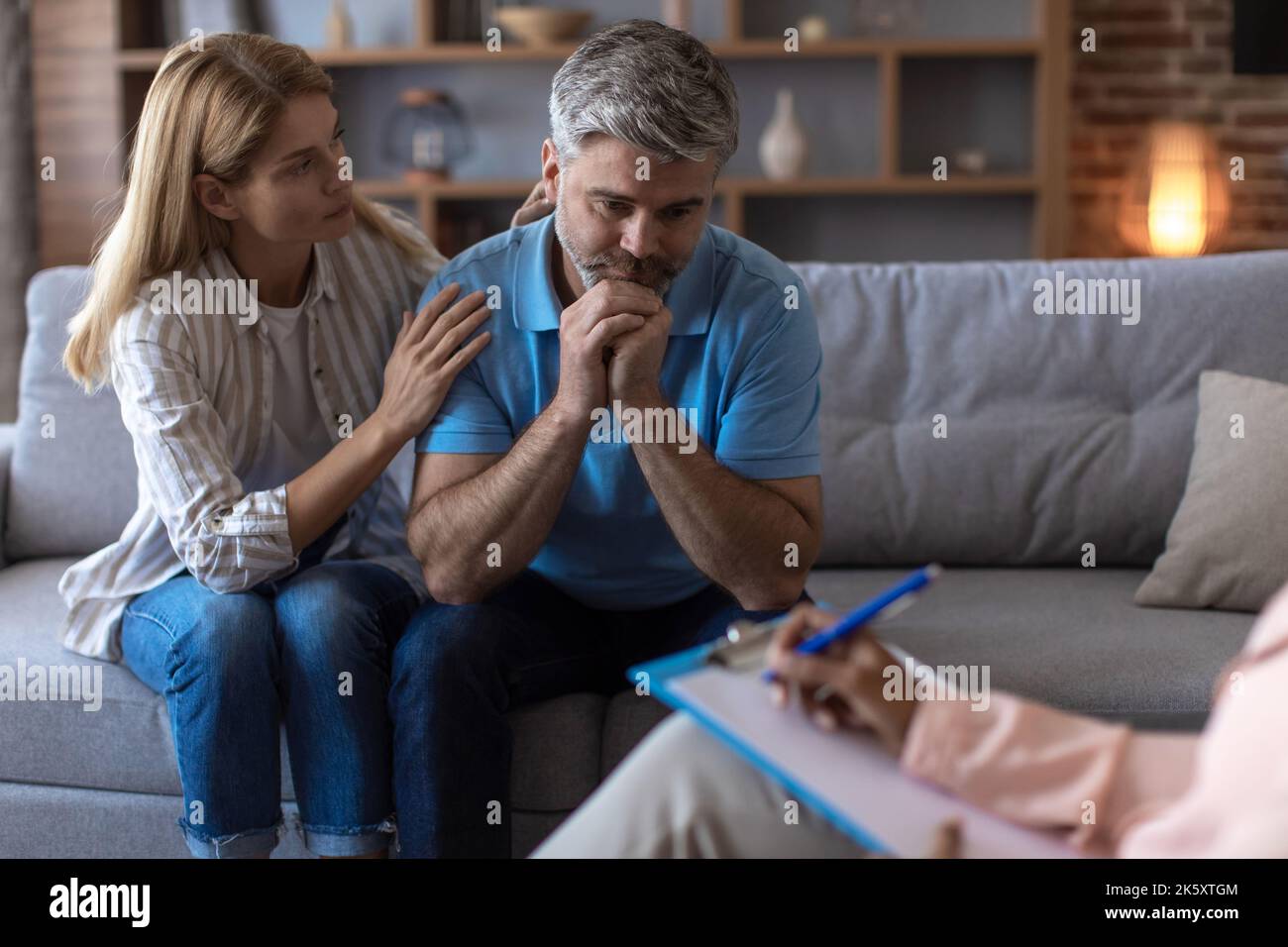 Une femme européenne d'âge moyen inquiète calme le mari déprimé lors d'une réunion avec un psychologue en clinique Banque D'Images