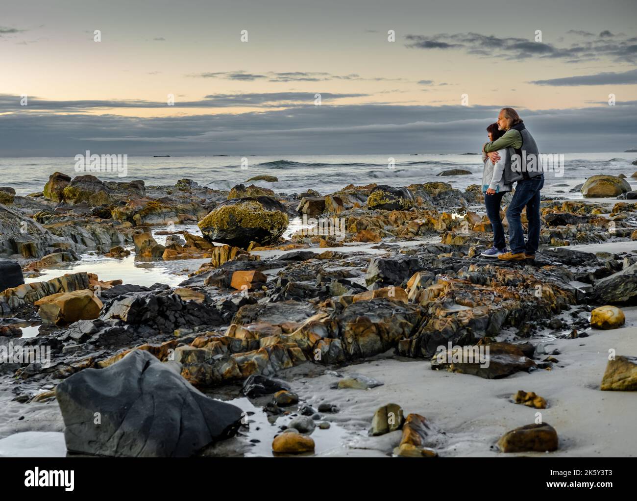 Un couple s'est levé tôt pour regarder le lever du soleil, même si les nuages où bloquant le soleil suffisamment de lumière du soleil est venu pour le rendre encore très beau. Banque D'Images