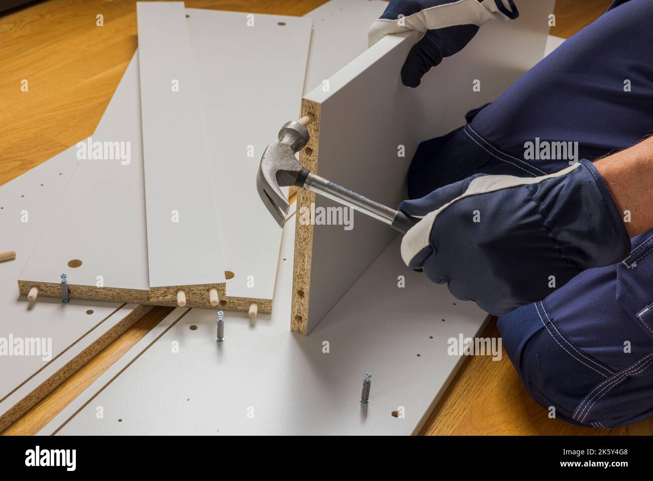 Vue rapprochée de l'armoire en martelant la cheville en bois. Suède. Banque D'Images