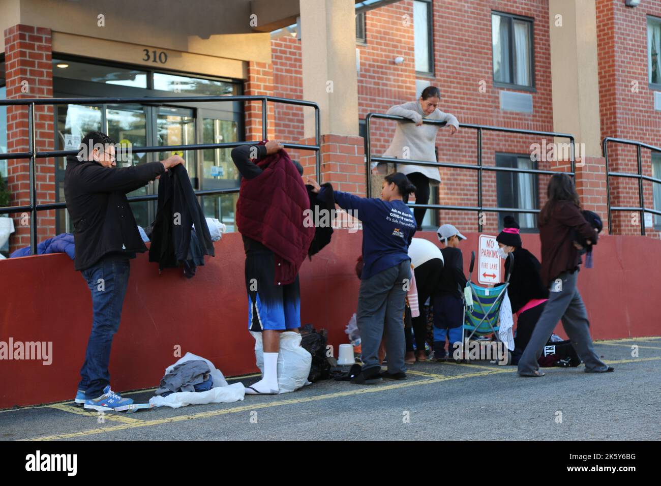 New York, États-Unis. 9th octobre 2022. Antonio Ovando (1st L), un demandeur d'asile arrivé à New York il y a moins d'une semaine, récupère les vêtements déposés par les New Yorkers devant un hôtel de Staten Island, New York, aux États-Unis, le 9 octobre 2022. Les milliers de demandeurs d'asile nouvellement arrivés à New York, la ville la plus peuplée des États-Unis, sont confrontés à des défis multiples pour s'enraciner dans une crise humanitaire en cours. Credit: Liu Yanan/Xinhua/Alay Live News Banque D'Images