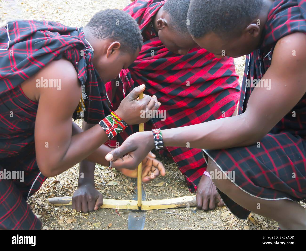 Masai hommes démontrant la technique pour commencer un feu Banque D'Images