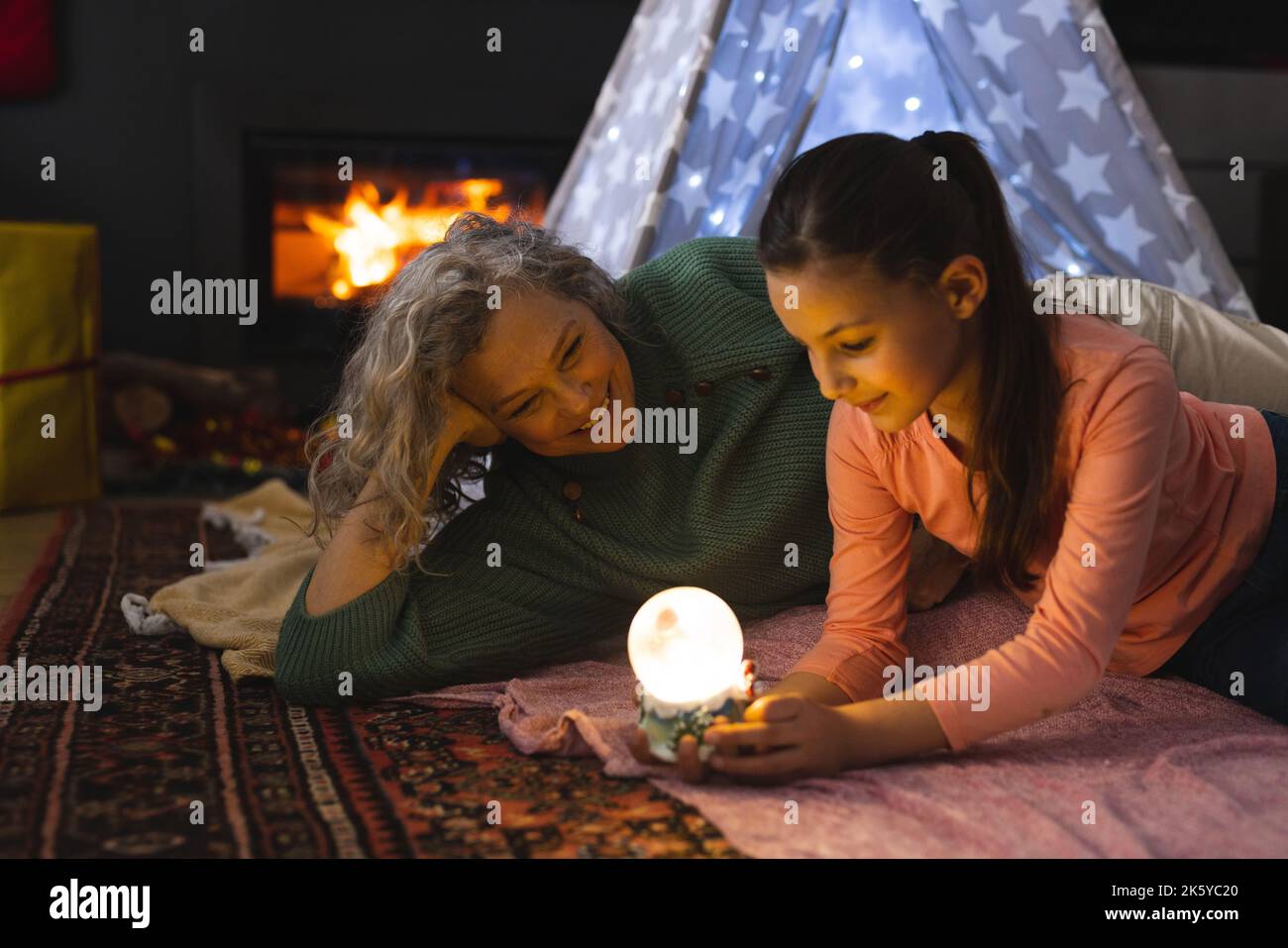Grand-mère et petite-fille caucasiennes couchée dans la tipi à côté du feu Banque D'Images