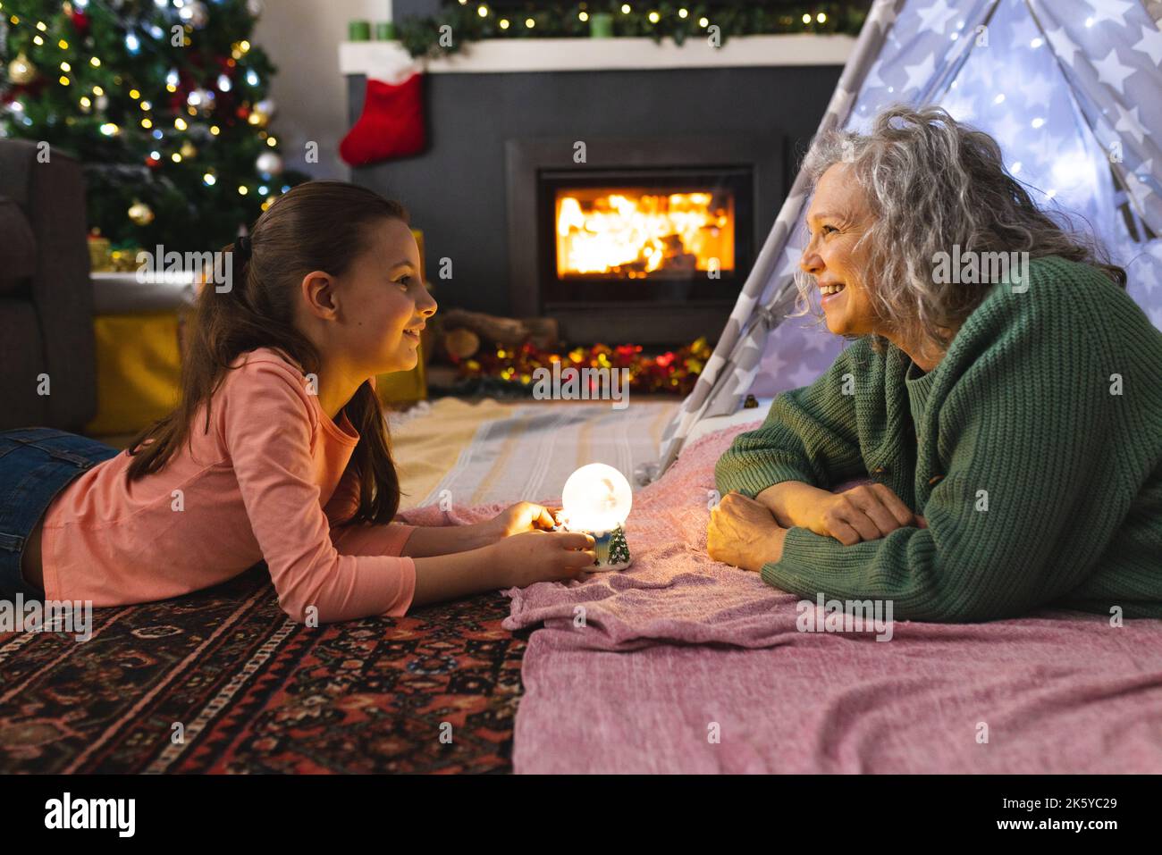 Grand-mère et petite-fille caucasiennes couchée dans la tipi à côté du feu Banque D'Images