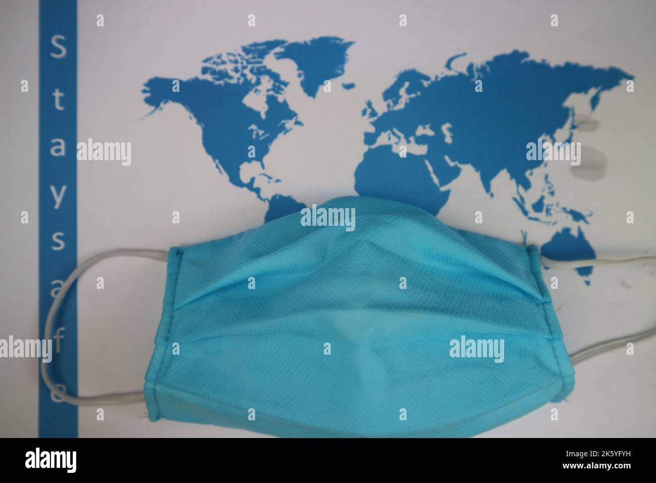 Masque de visage avec carte du monde. L'épidémie de Covid-19 dans le monde entier. Crise économique mondiale. Accident par le virus corona. Vivre en confinement dans le monde entier Banque D'Images